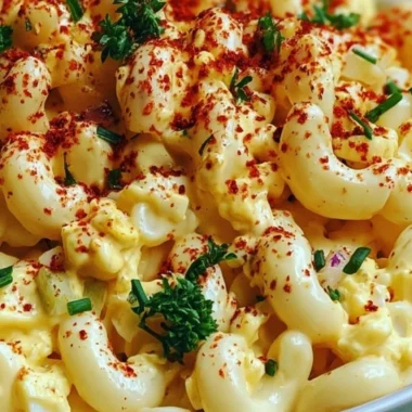 Bowl of Deviled Egg Macaroni Salad with garnishes