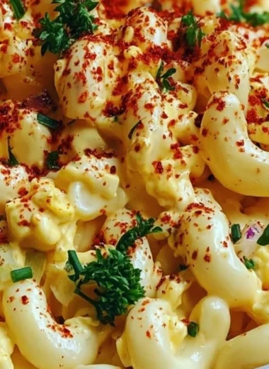 Bowl of Deviled Egg Macaroni Salad with garnishes