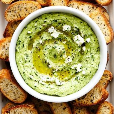 Green Goddess Feta Dip with herbs in a bowl, served with colorful vegetables.