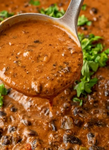 Bowl of hearty black bean soup garnished with cilantro and lime