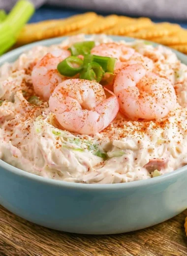 Delicious shrimp dip served in a bowl with fresh herbs and crackers