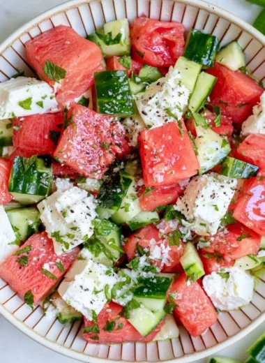Colorful watermelon cucumber feta salad in a bowl, garnished and ready to serve
