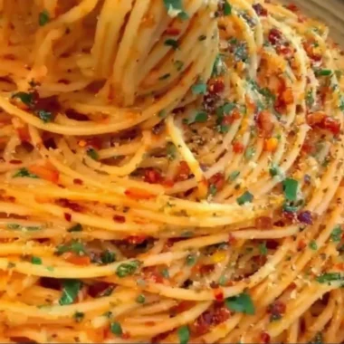 Delicious Spaghetti Cacio e Pepe topped with chili flakes and thyme.