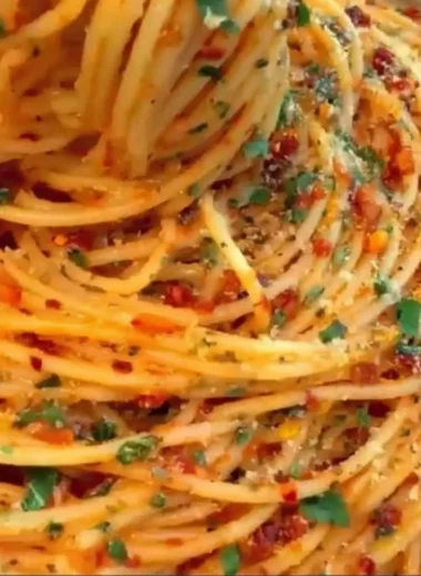 Delicious Spaghetti Cacio e Pepe topped with chili flakes and thyme.