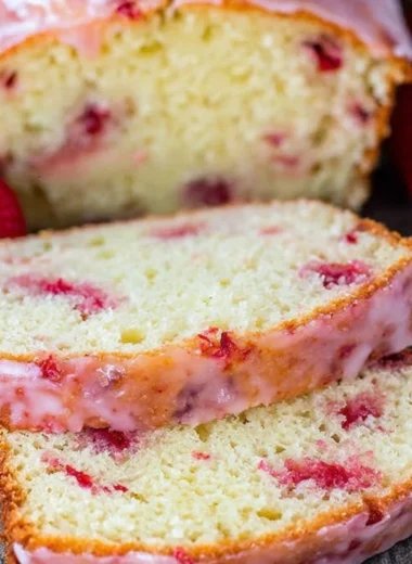 Delicious strawberry pound cake topped with fresh strawberries and whipped cream