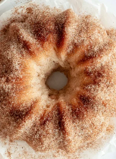 Delicious apple cider donut cake with fresh apples and cinnamon topping.