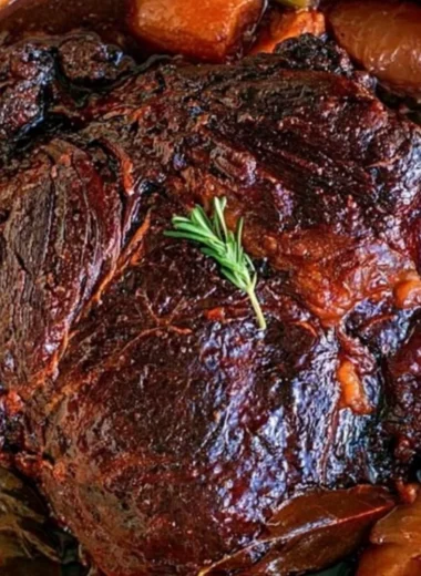 Deliciously prepared beef chuck roast served with vegetables and herbs