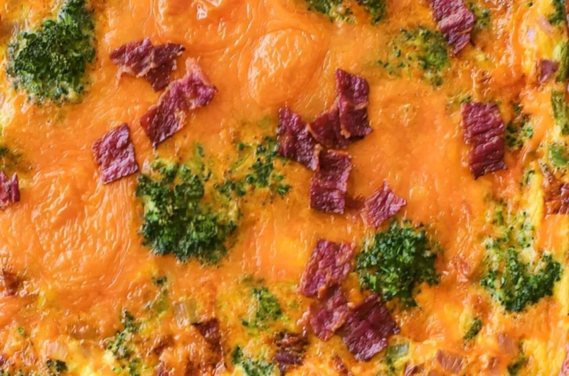 Broccoli Cheddar Egg Bake with Turkey Bacon served in a dish