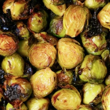 Brussels sprouts drizzled with rich balsamic glaze on a rustic plate