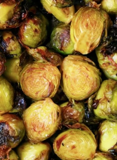 Brussels sprouts drizzled with rich balsamic glaze on a rustic plate