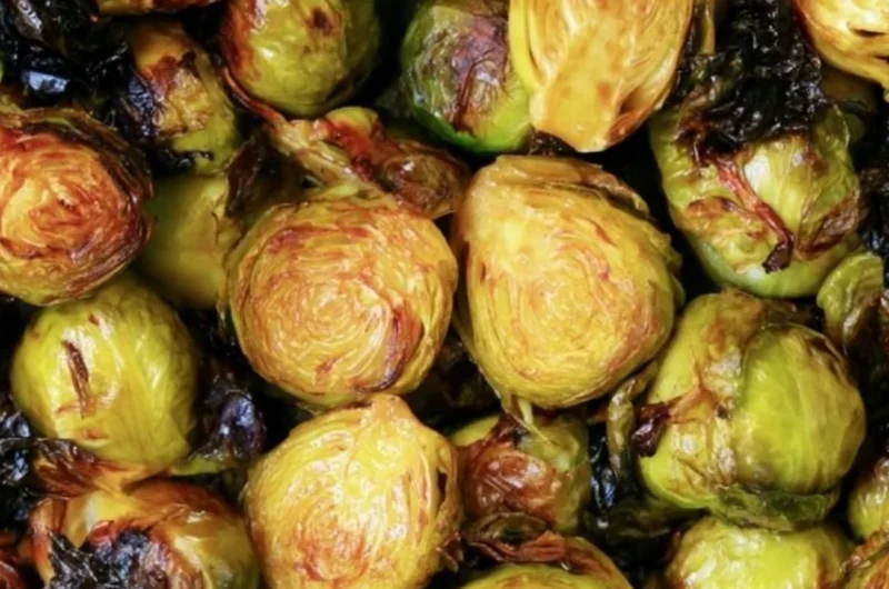 Brussels sprouts drizzled with rich balsamic glaze on a rustic plate