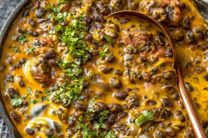 Bowl of Easy Creamy Black Bean Curry served with rice and herbs