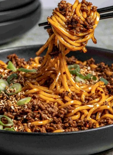 Plate of easy Mongolian ground beef noodles garnished with green onions