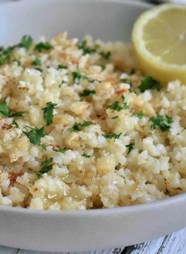 Delicious Garlic Butter Cauliflower Rice in a bowl, garnished with herbs.