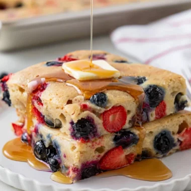 Gluten-free sheet pan pancake baked and served with fruits on top.