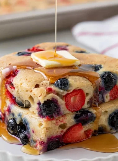 Gluten-free sheet pan pancake baked and served with fruits on top.