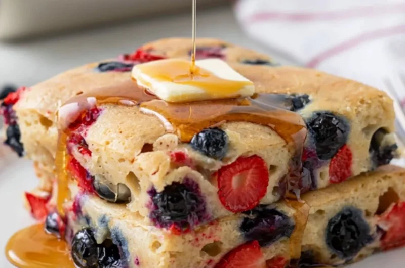 Gluten-free sheet pan pancake baked and served with fruits on top.