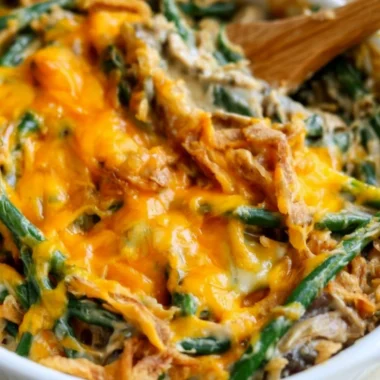 A serving of green bean casserole topped with crispy onions and cream.