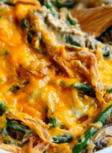 A serving of green bean casserole topped with crispy onions and cream.