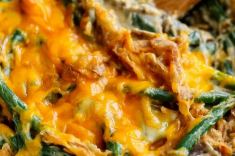 A serving of green bean casserole topped with crispy onions and cream.