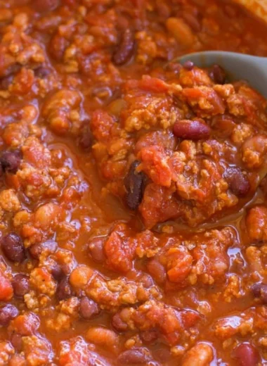 A bowl of healthy turkey chili garnished with fresh herbs and spices.