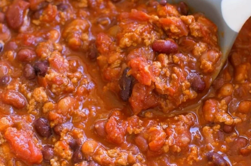 A bowl of healthy turkey chili garnished with fresh herbs and spices.
