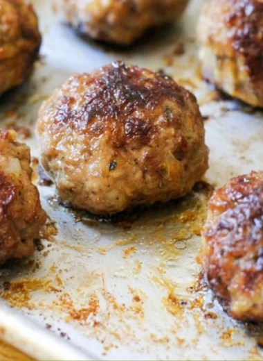 Delicious homemade meatballs on a plate with sauce and herbs