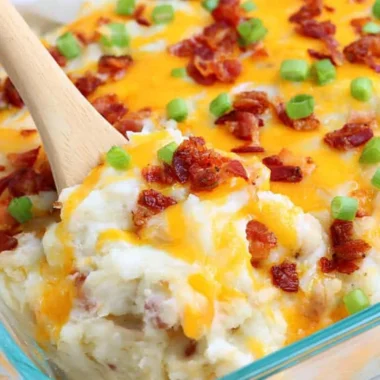 Loaded baked potato casserole topped with cheese and green onions