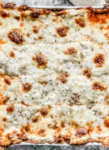 Delicious Million Dollar Spaghetti served in a bowl with cheese and herbs.