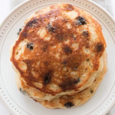 Delicious stack of fluffy sourdough pancakes served with syrup and berries