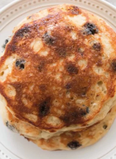 Delicious stack of fluffy sourdough pancakes served with syrup and berries