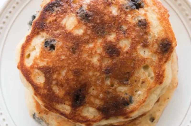 Delicious stack of fluffy sourdough pancakes served with syrup and berries