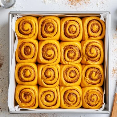 Freshly baked pumpkin cinnamon rolls topped with cream cheese frosting