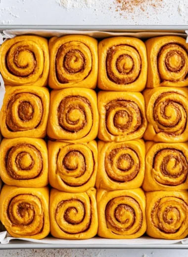 Freshly baked pumpkin cinnamon rolls topped with cream cheese frosting