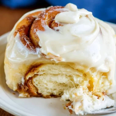 Freshly baked sourdough cinnamon rolls drizzled with icing.