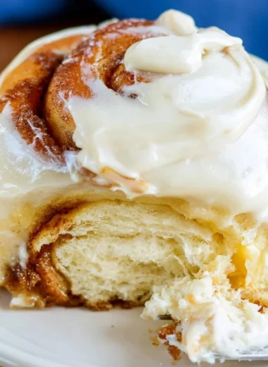 Freshly baked sourdough cinnamon rolls drizzled with icing.