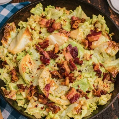 Southern Fried Cabbage cooked with crispy bacon, served in a skillet.