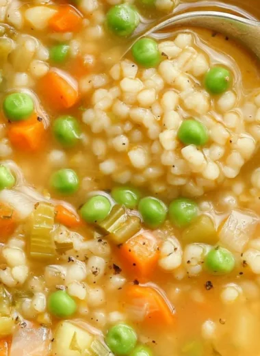 Bowl of Veggie Barley Soup with fresh vegetables and barley grains.