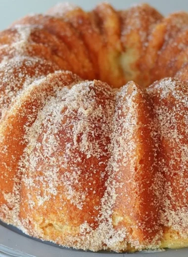 Apple Cider Bundt Cake drizzled with caramel apple glaze on a white plate