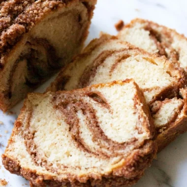 Cinnamon swirl vanilla pound cake slice on a plate with a cinnamon stick