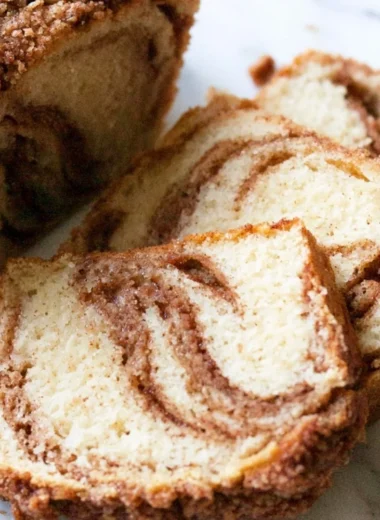 Cinnamon swirl vanilla pound cake slice on a plate with a cinnamon stick