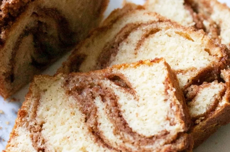 Cinnamon swirl vanilla pound cake slice on a plate with a cinnamon stick