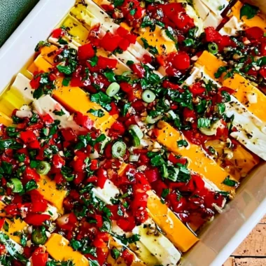 Delicious marinated cheese in a bowl with herbs and spices