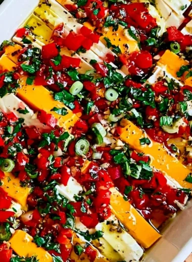Delicious marinated cheese in a bowl with herbs and spices