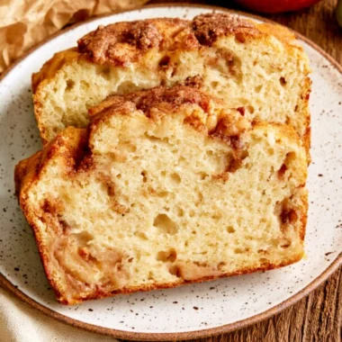 A loaf of moist and tender cinnamon apple bread garnished with cinnamon sticks