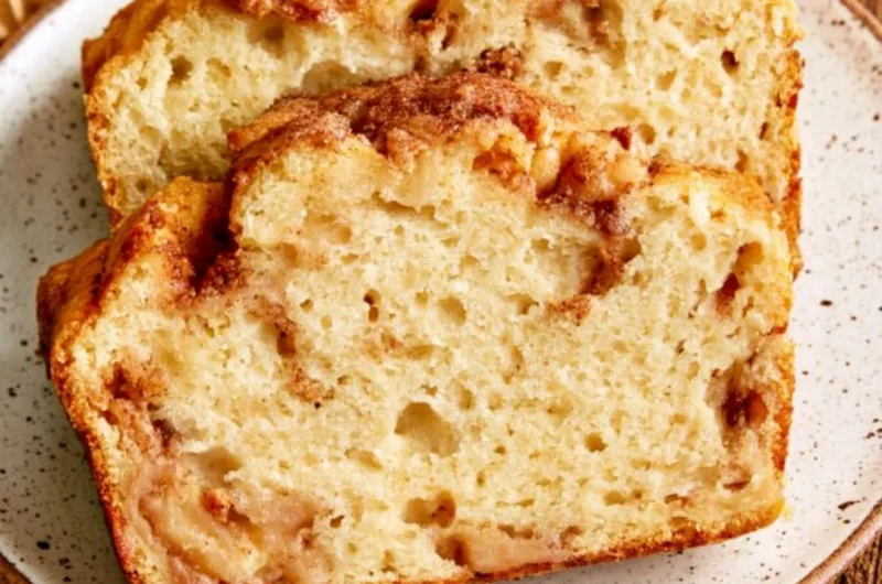 A loaf of moist and tender cinnamon apple bread garnished with cinnamon sticks